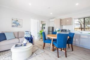 un soggiorno con divano, tavolo e sedie di 'Redcliffe Retreat' Moreton Bay Coastal Cottage a Redcliffe