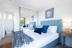 a blue and white bedroom with a large bed at 'Redcliffe Retreat' Moreton Bay Coastal Cottage in Redcliffe