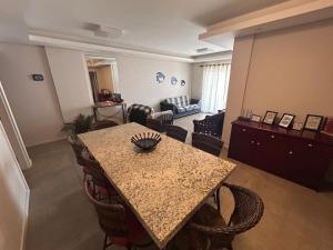 ein Zimmer mit einem Tisch mit Stühlen und ein Wohnzimmer in der Unterkunft APARTAMENTO FRENTE MAR in Itapema