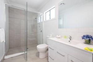 a bathroom with a shower and a toilet and a sink at 'Redcliffe Retreat' Moreton Bay Coastal Cottage in Redcliffe