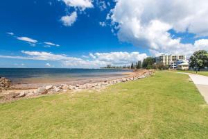雷德克利夫'Redcliffe Retreat' Moreton Bay Coastal Cottage的从公园欣赏海滩美景