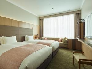 a hotel room with two beds and a couch at Hotel The Celestine Tokyo Shiba in Tokyo