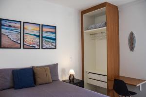 a bedroom with a bed with three paintings on the wall at Ubatuba North Shore in Ubatuba +44 photos