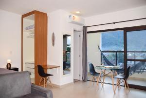 a living room with a couch and a table with chairs at Ubatuba North Shore in Ubatuba