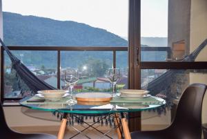 a table with glasses and plates on it with a view at Ubatuba North Shore in Ubatuba