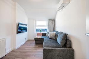 a living room with a couch and a tv at London Paddington Station Apartments in London