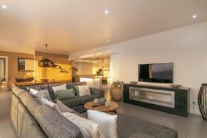 Una gran sala de estar con un sofá y un televisor. en BQ6 - Pezula Gucci's Luxury Retreat -, en Knysna
