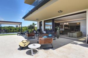 a patio with couches and chairs and tables at Luxus Villa La Casaccia mit Meerblick Medulin,Istrien in Medulin