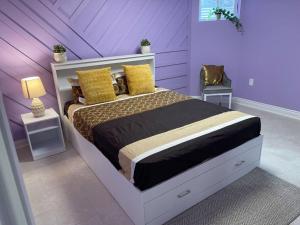 ein Schlafzimmer mit einem großen Bett mit lila Wänden in der Unterkunft Sweet Home with beautiful ambiance 2 bedroom in Brampton