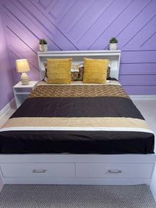 a purple bedroom with a large bed with yellow pillows at Sweet Home with beautiful ambiance 2 bedroom in Brampton