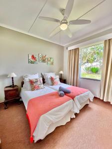a bedroom with two beds and a ceiling fan at St Lucia Holiday Cottage in St Lucia