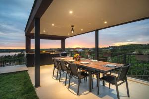 a dining table on the deck of a house at Luxus Villa La Casaccia mit Meerblick Medulin,Istrien in Medulin