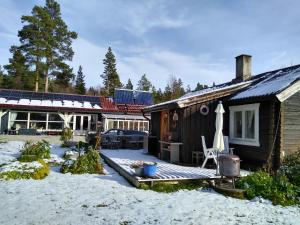 una casa con terraza en la nieve en Furuly vakantiehuis en Vingelen