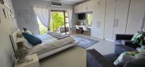 ein Schlafzimmer mit einem Bett und einem Sofa sowie ein Wohnzimmer in der Unterkunft Venti Dell'Est in Westbrook