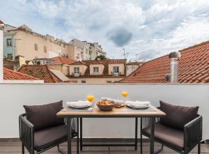 een tafel op een balkon met 2 glazen sinaasappelsap bij Ama Apartments in Lissabon +25 foto's