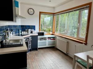a small kitchen with a sink and a window at The Annexe at Cluny House in Inverness