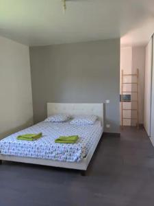 een slaapkamer met een bed met groene handdoeken erop bij Charmante villa d.Architecte 200m2 à 20 min de la mer in Saint-Geniès-de-Fontedit
