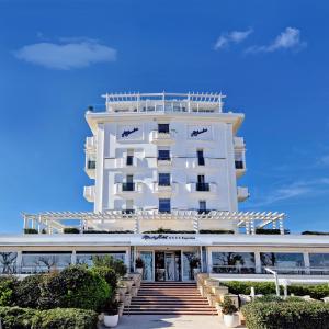 a large white building with stairs in front of it at Hotel Atlantic in Riccione
