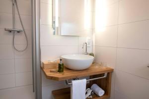 a bathroom with a white sink and a shower at Holzfellas Home in Wiesau