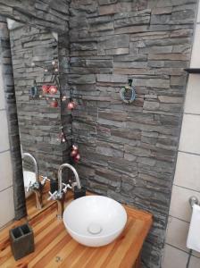 baño con lavabo y pared de piedra en La Casita, en Agulo