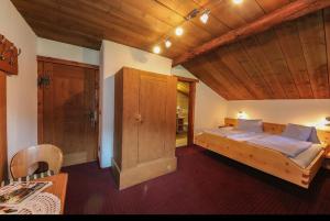 a bedroom with a large bed and a wooden ceiling at Pension Hochwart Hof in Saalbach-Hinterglemm