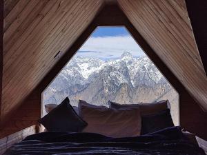 a bed in a room with a large window at Poppy Resorts Auli in Joshīmath