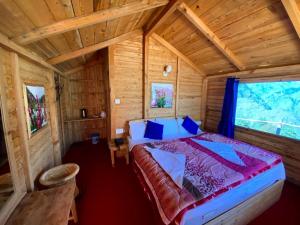 Poppy Resorts Auli في جوشيماث: غرفة نوم بسرير في كابينة خشبية