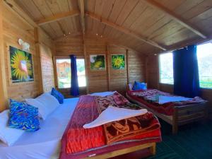 Poppy Resorts Auli في جوشيماث: غرفة نوم بسريرين في غرفة خشبية