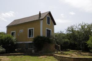 een huis in een veld met gras en bomen bij Maison dans le bourg, 6-8 couchages avec piscine in Groléjac