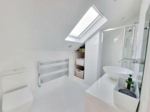 uma casa de banho branca com um lavatório e um espelho em West Hill Retreat Seaview Balconette Loft Apartment with Free Parking em Hastings