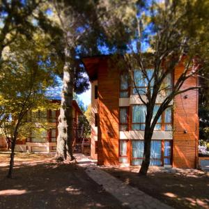 un edificio con árboles delante de él en Villa Sofía Apart Hotel en San Carlos de Bariloche