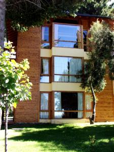 un edificio con ventanas de cristal en un lateral en Villa Sofía Apart Hotel en San Carlos de Bariloche