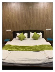 een bed met groene en witte kussens erop bij Auli Eco Nature Resort in Joshimath