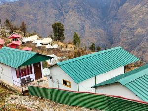 a group of buildings with green roofs on a mountain at Auli Eco Nature Resort in Joshīmath
