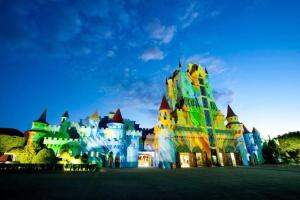 a disney castle is lit up at night at Apart Luis in Penha