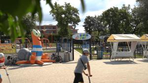 un grupo de personas caminando por un parque infantil en Easyatent Mobile home Bijela Uvala, en Poreč