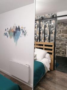 a bedroom with a bed in a room with a wall at Charmant appartement de village in Pennautier