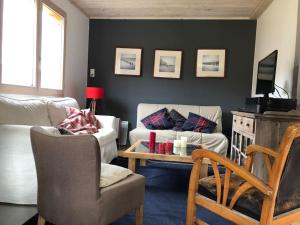 a living room with a couch and a table at Chalet cosy et confortable in Savoie