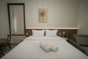 a hotel room with a bed with two towels on it at Vida Boa Pousada in Águas de Lindóia