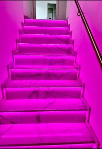 una escalera en una habitación rosa con luces rosas en Pension Hanna, en Waldbronn