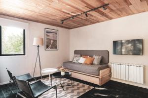 ein Wohnzimmer mit einem Sofa und Stühlen in der Unterkunft Villa Sofía Apart Hotel in San Carlos de Bariloche