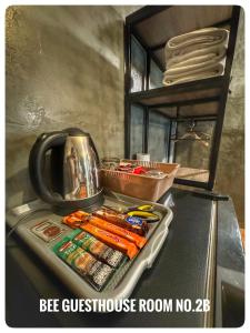 a kitchen counter with a tray of utensils and a tea kettle at The One House in Nan