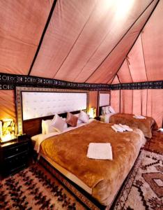 a bedroom with a large bed in a tent at Luxury Local Camp in Merzouga