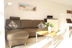 ein Wohnzimmer mit einem Sofa und einem Tisch in der Unterkunft Dünenhäuser Haus 3 in Boltenhagen