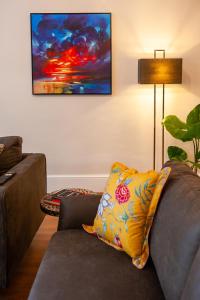 a living room with a couch and a painting on the wall at Primrose Hill Apartments in London