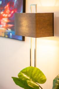 a lamp on a table with a green plant at Primrose Hill Apartments in London