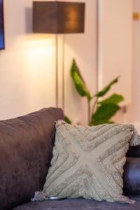 a pillow sitting on top of a couch with a plant at Primrose Hill Apartments in London