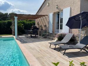 une terrasse avec une piscine, des chaises et un parasol dans l'établissement Chez Liselotte, à Borgo