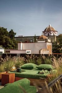 a garden with green pillows and a building in the background at Otro Oaxaca, a Member of Design Hotels in Oaxaca City