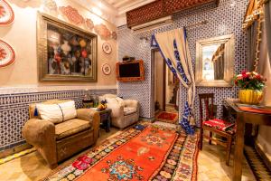 Una sala de estar con paredes de azulejos azules y blancos. en Riad Hikaya, en Marrakech